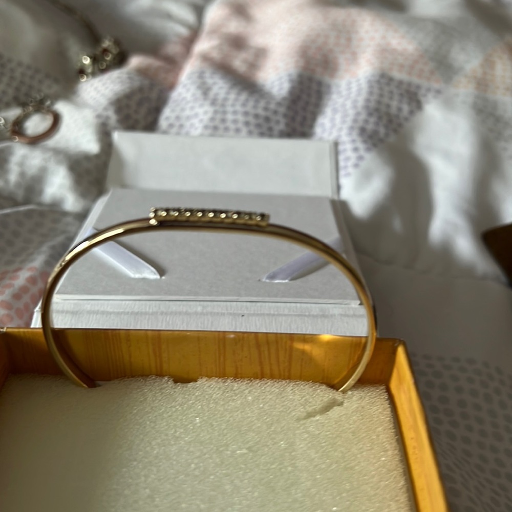 Gold tone oval bangle with accent stones